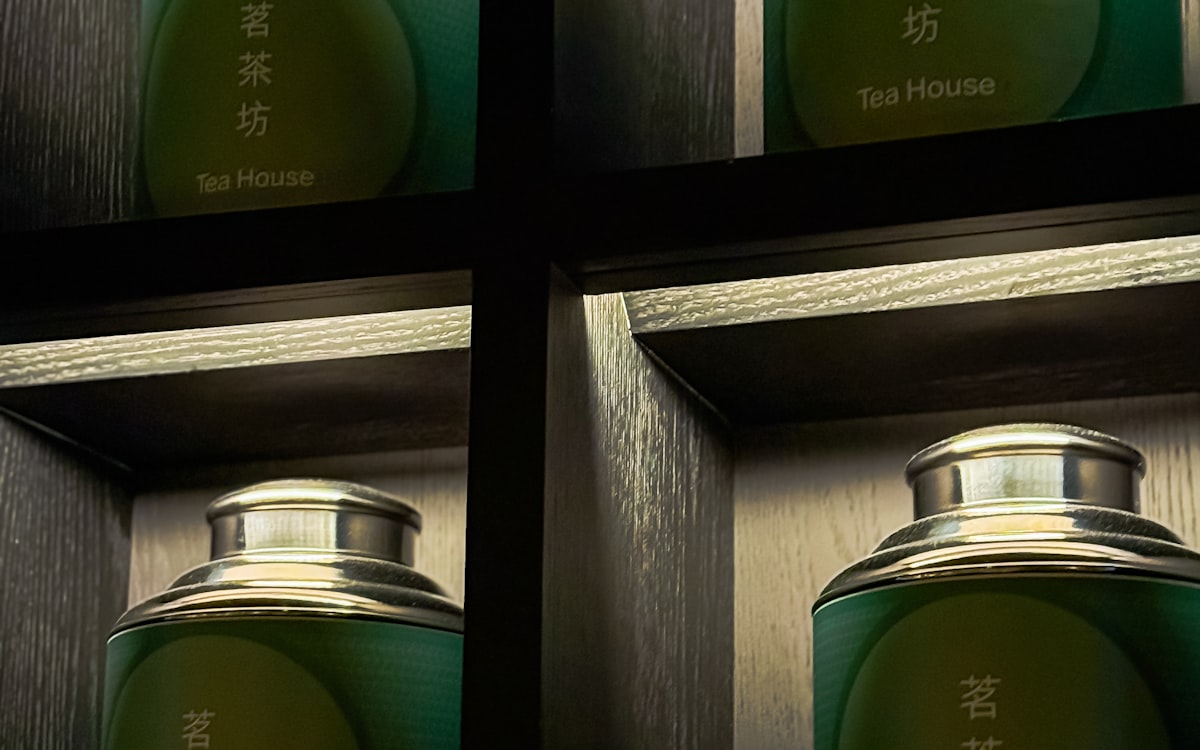 Batch-numbered tins on a dark shelf